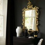 Decorating with mirrors - black wall and gold ornate mirror