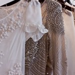 Beaded and detailed frocks hanging on rack - lace, white, silver