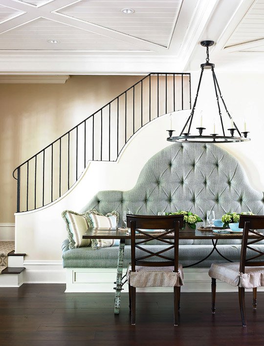 Dining area with tufted banquette seating and staircase